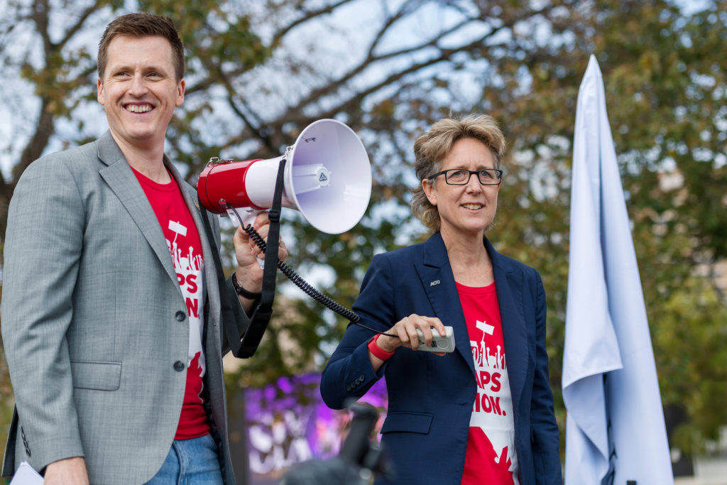 SA Unions Dale Beasley stands with a megaphone next to Sally McManus
