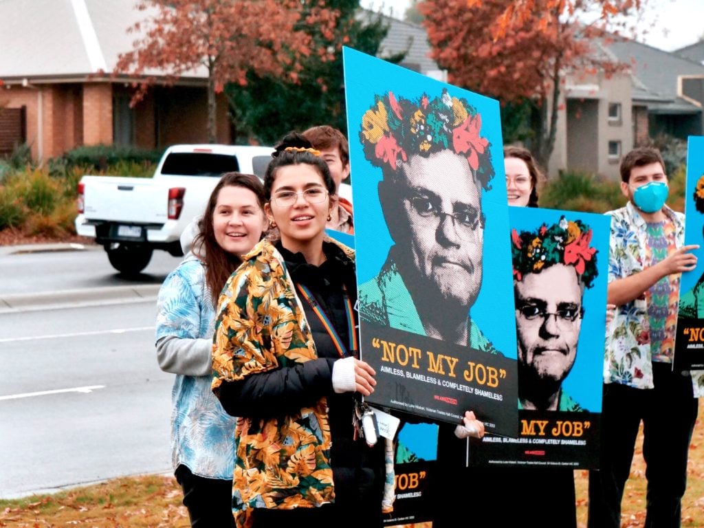 ASU members hold a sign with Scott Morrison saying "not my job"